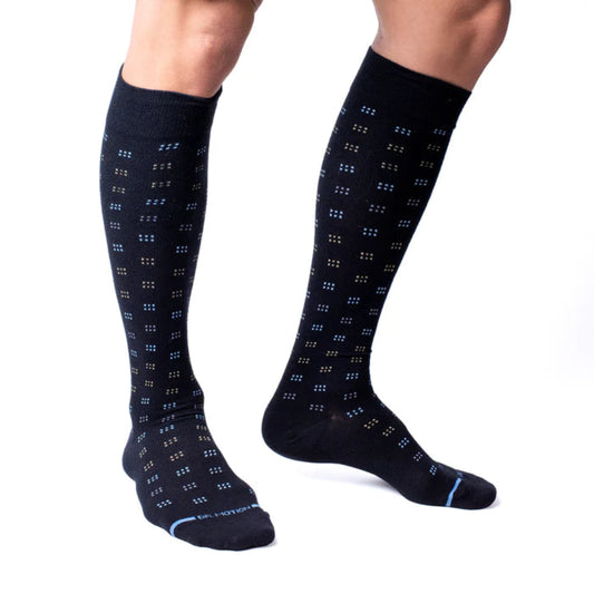 Black knee-high socks with blue pattern worn by a person on a white background