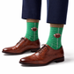 Green socks with football design worn with brown dress shoes and navy pants on a white background