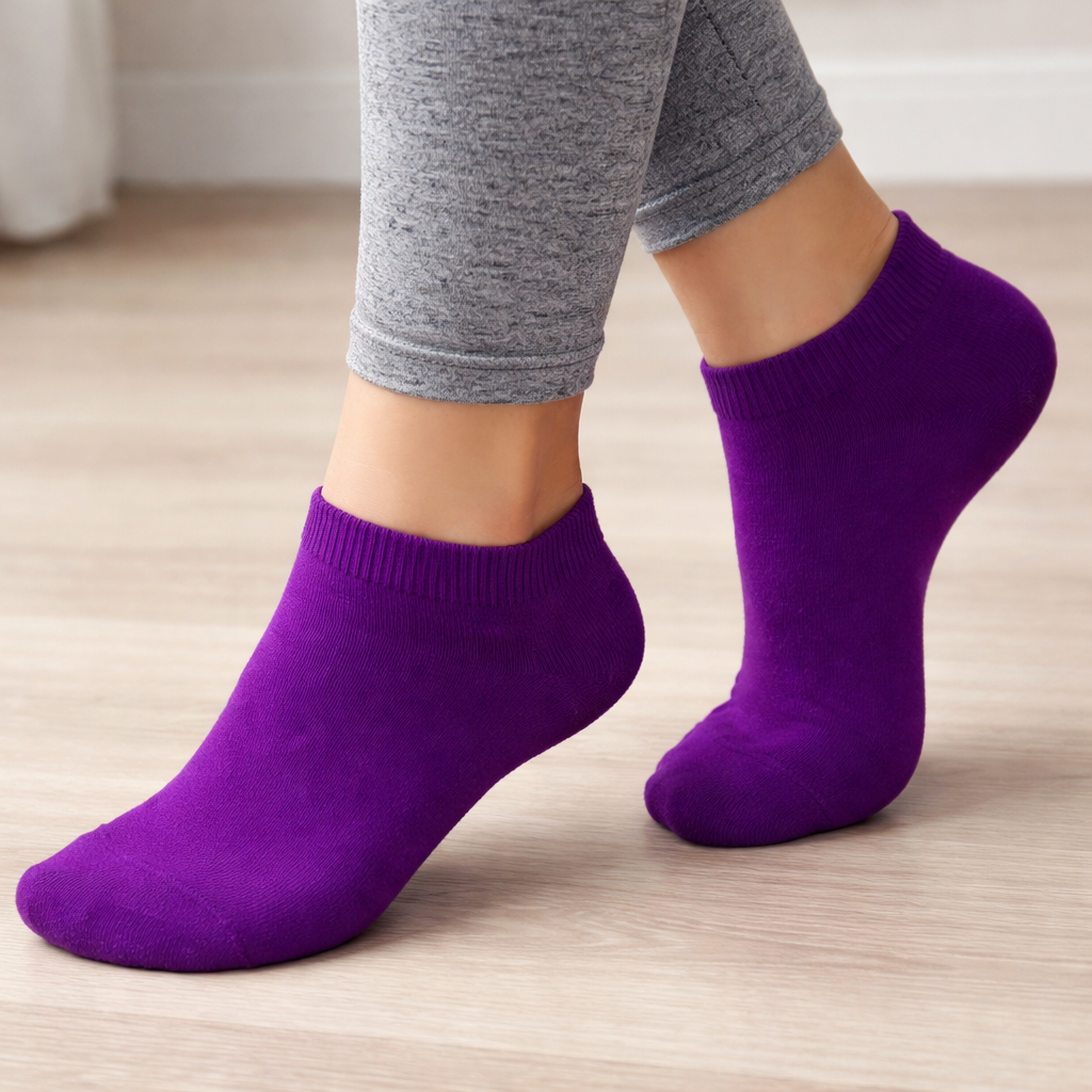 Ankle Purple socks worn with gray leggings on a light wooden floor.