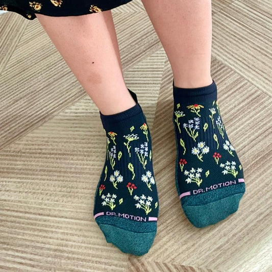 Woman relaxing at home wearing Dr. Motion floral ankle compression socks