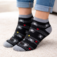 Black Halloween Ankle socks with white star and red heart patterns worn by a person on a light carpet.