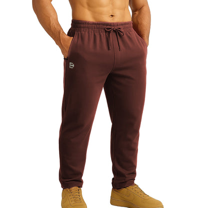 Maroon jogger pants worn by a person on a white background