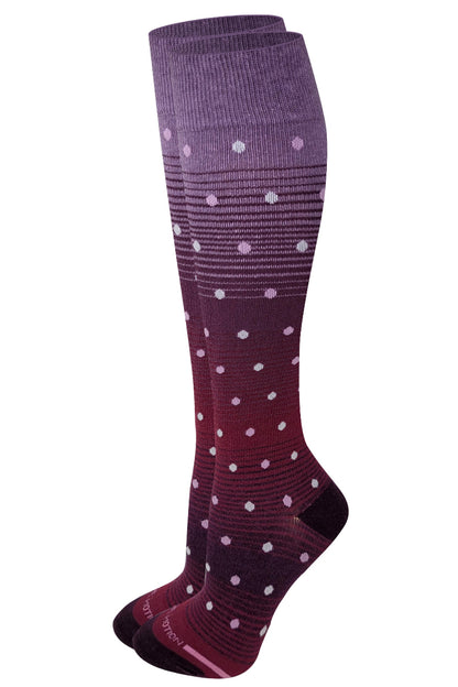 Purple knee-high socks with white polka dots on a white background