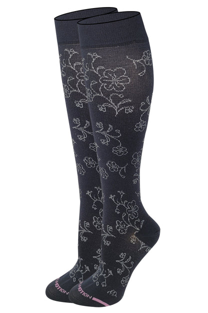 A pair of dr motion knee-high compression socks with a floral pattern in black color.